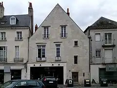 Photogarphie en couleurs d'une façade avec des baies en arc brisé murées.