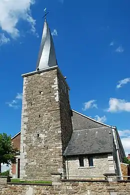 La tour du XVIe&nbsp;siècle surmontée du clocher tors de 1840 avec le porche néoroman à droite.