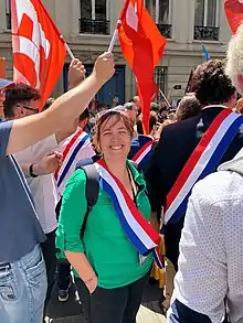 Elise Leboucher portant son écharpe de députée lors d'une manifestation.