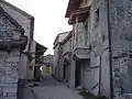 Sur la gauche, un angle de la Maison du Karst avec son toit de lauzes et sa gouttière en pierre
