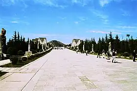 Une vue de la voie de l'esprit du mausolée de Qianling datant de la dynastie Tang. Les vestiges du troisième ensemble de tours " Que " sont visibles à mi-distance. Originellement, les plates-formes en pierre auraient été surmontées de structures en forme de pavillons.