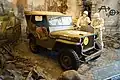 Jepp Willys olive drab avec l'étoile blanche cerclée, l'insigne de grande unité marqué sur le pare-choc.