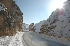 Photo en couleur de rochers formant un défilé, dans lequel passe une route