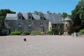 Vue d'un édifice à trois étages, couvert d'ardoise. À droite, une tour attenante.