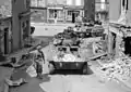 Une unité américaine avec voiture blindée dans un village lors de la Libération de la France.