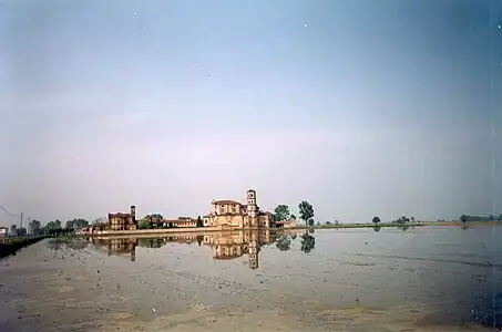 Photographie couleur d'une rizière entourant une abbaye.