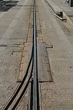 Un aiguillage sur la voie du TVR, à proximité de l'arrêt "Saint-Georges". Les deux rails étaient sur une plaque commune, qui pivotait en fonction du rail à aligner. Cet aiguillage était abandonné depuis 2005, et a en conséquence été soudé sur le rail encore en service.