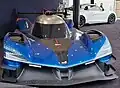 Photo de l'avant d'une voiture de course bleue et noire sur un stand d'exposition.