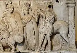 Longue frise sculptée. Nombreux figurants, dont plusieurs soldats en armes.