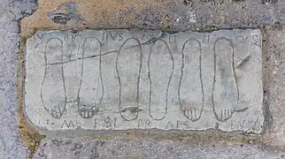 Tablette votive à l'entrée de l'amphithéâtre dédiée à Némésis.
