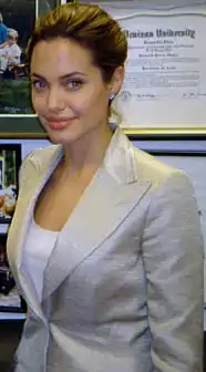 Angelina Jolie, femme aux cheveux châtains, se tient en face d'un mur