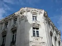  Photographie du haut d'une façade d'immeuble décoré de bustes de femmes.