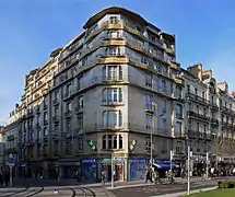 Photographie d'une façade d'immeuble de grande hauteur, d'une teinte dorée et bleutée.