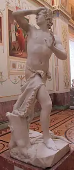 Statue de marbre. Un homme, marchant, se retourne, une main sur le front, l'autre à demi levée, l'air désespéré.