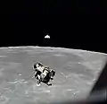 Photographie en couleur du module lunaire remontant vers le module de commande depuis la Lune.