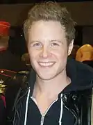 Ashton Holmes interprète Sid Phillips (en)
