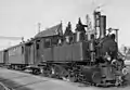 La locomotive-tender type Mallet B.L.E.A.G. 5 bis 8 (de) dans une gare de Karlsruhe, Allemagne. Mars 1958.