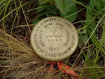 Borne géodésique dans le Colorado, marquant l'angle de la section 6 du 3e&nbsp;township au nord et de la 75e&nbsp;rangée à l'ouest (T3N R75W s6). Dessus : « Penalty $250 for removal ».
