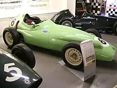 Photographie d'une BRM P25 vert pistache, vue de trois-quarts, dans un musée d'exposition.