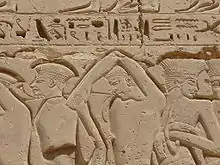 Fresque sur fond rougeâtre.