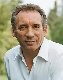 Photographie en couleurs d'un homme souriant.