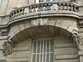 No&nbsp;64 : détail du balcon, montrant la date de construction de l'immeuble.