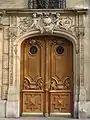 No&nbsp;92 : porte en bois sculpté, avec sphinx ailés. Dessus de porte avec angelots.
