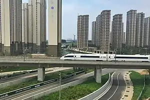 Urbanisation dense, architecture de grande hauteur (25-30 étages). Voies rapides. LGV Pékin - Canton, 2&nbsp;298&nbsp;km à 300&nbsp;km/h, ici/ Zhengzhou, ligne ouverte en 01-2013.