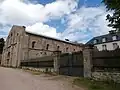Vue de côté de l'abbatiale et entrée de l'abbaye, avant la construction de l'aile ouest et de l'aile sud (2017-2019).