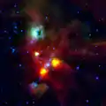 La lueur verte entourant le trou est causée par l'intense rayonnement de l'étoile V380. (Télescope spatial Herschel)