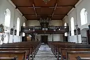 Vue intérieure de la nef vers la tribune d'orgue.