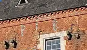 Initiales en briques vernissées P L B , soit Pargny-lès-Bois.