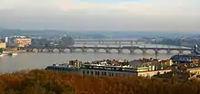 Photographie aérienne du pont de Pierre et de la Passerelle Eiffel. En avant plan, on distingue des arbres aux couleurs rougeatres.