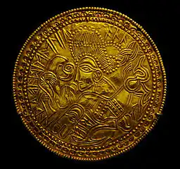 Bractéate avec un visage et l'inscription runique « Le Très Haut », un nom d'Odin.