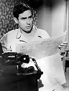 Homme blanc lisant un journal.