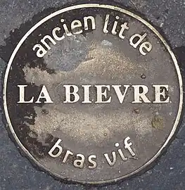 Médaillon au sol rappelant le tracé du bras vif de la Bièvre, posé en 2008.