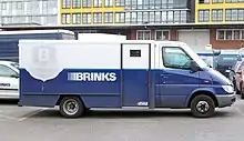 Photo d'un camion blanc et bleu dans une rue.