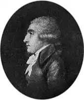 Side view of the head and upper body of a fellow wearing a dark jacket and white ruffled collar.