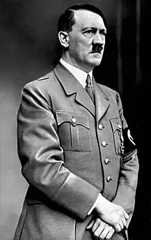 Photographie représentant le portrait d'un homme de type caucasien, vêtu d'un costume militaire clair.
