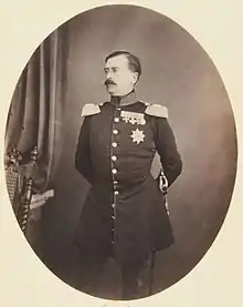 portrait en pied, de trois-quarts, de Charles-Antoine, revêtu d'un uniforme à épaulettes et arborant des médailles, regarde vers sa gauche, le visage à l'expression neutre porte une moustache foncée aux pointes effilées