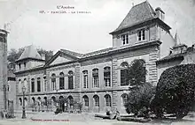 Phototyoie d'un bâtiment de deux étages du début du XXe siècle. Au centre fronton au-dessus de deux fenêtres, deux ailes de trois fenêtres et à chaque extrémité surélévation d'un étage au-dessus d'un corps de bâtiment à deux fenêtres.