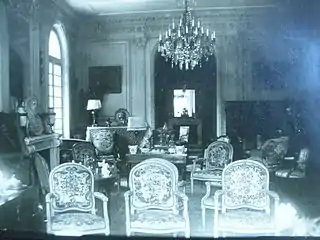 Salon richement meublé au début du XXe siècle.