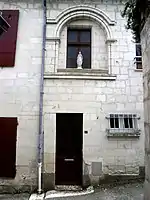 photographie en couleurs d'une façade percée d'une baie en plein cintre.