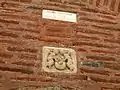 Façade nord : inscription de 1892 portant sur la restauration de la façade, et bas-relief médiéval représentant la montée d'une âme au ciel