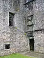 Entrée du château surplombée d'un panneau vierge encadré.