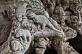 Tronc d'arbre sculpté avec des reliefs de dinosaure, oiseau, ours, lapin et tortue, vu dans le jardin du temple bouddhique de Vat Phra Kèo.