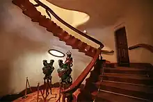 Escalier en bois clair sur fond blanc.