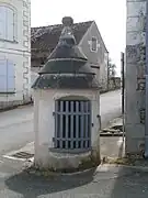 Vue d'une petite tourelle couverte en pierre et munie d'une porte grillagée