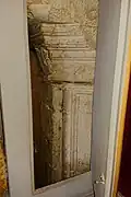 Détail de la cheminée en pierre sous le lambris.