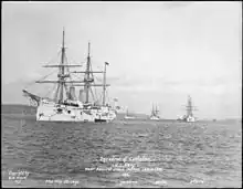 Photographie de quatre navires blancs dont les gréements ne portent pas de voiles